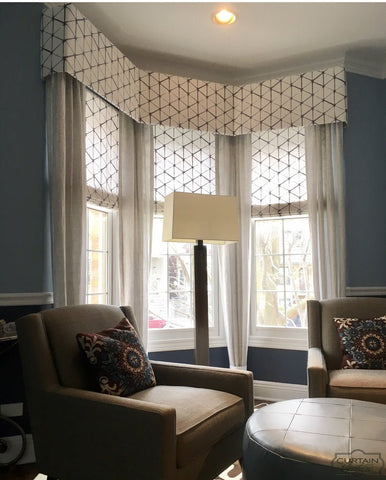 Contemporary geometric flat roman shades with matching cornices, completed with stationary panels. This creates a soft surrounding with enough sunlight filtered through.
