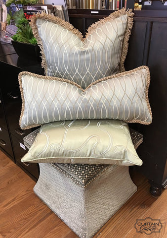 Pillows on top of Upholstered ottoman by Curtain Couture